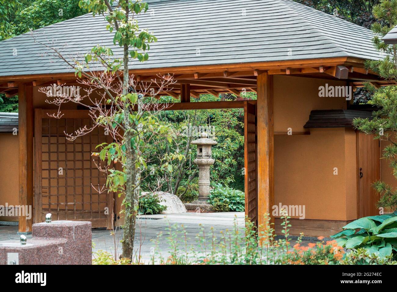 Looking at a stone lantern through the entrance to the japanese garden