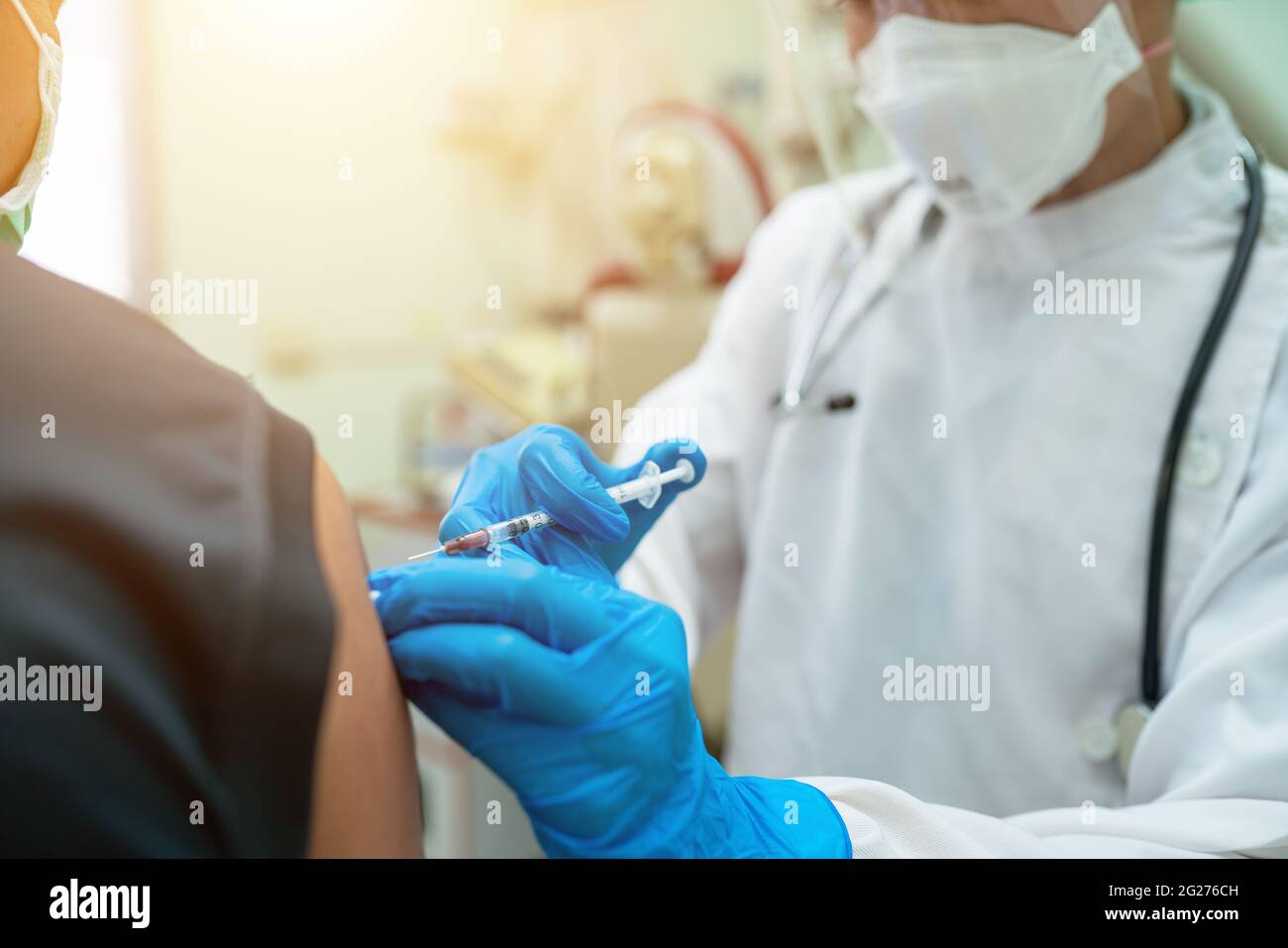 Doctors inject people with vaccines to build their body's immunity against the coronavirus or COVID-19. Stock Photo