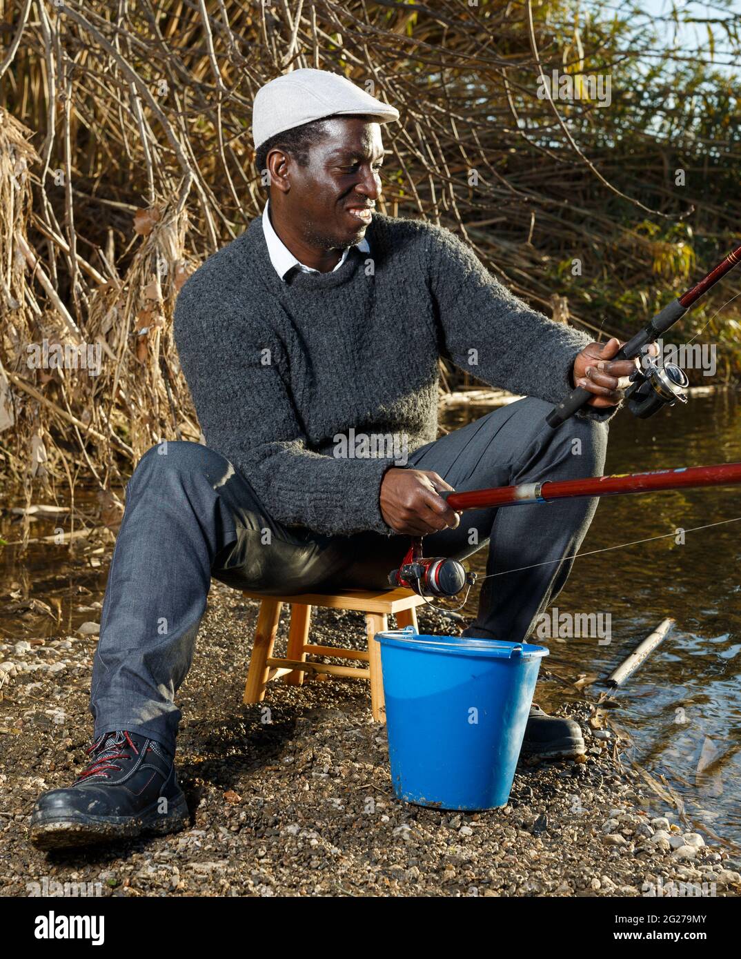 Man sitting on bucket fishing hi-res stock photography and images - Alamy