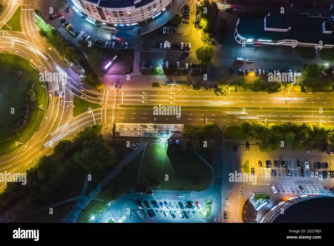 roundabout intersection and city street. road traffic with car light trails. aerial top view at night. Stock Photo