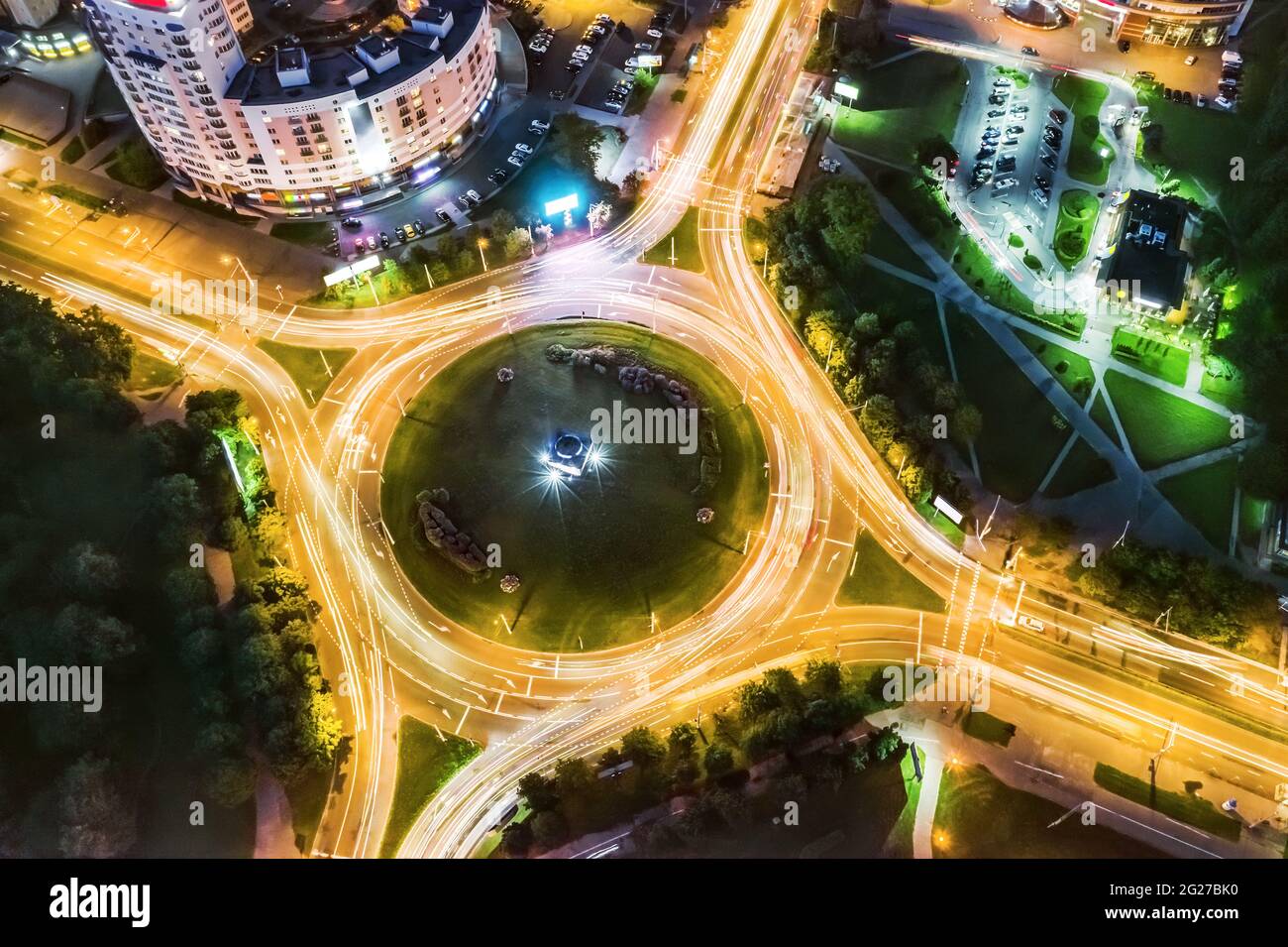 roundabout with car light trails at night. aerial view from flying drone Stock Photo