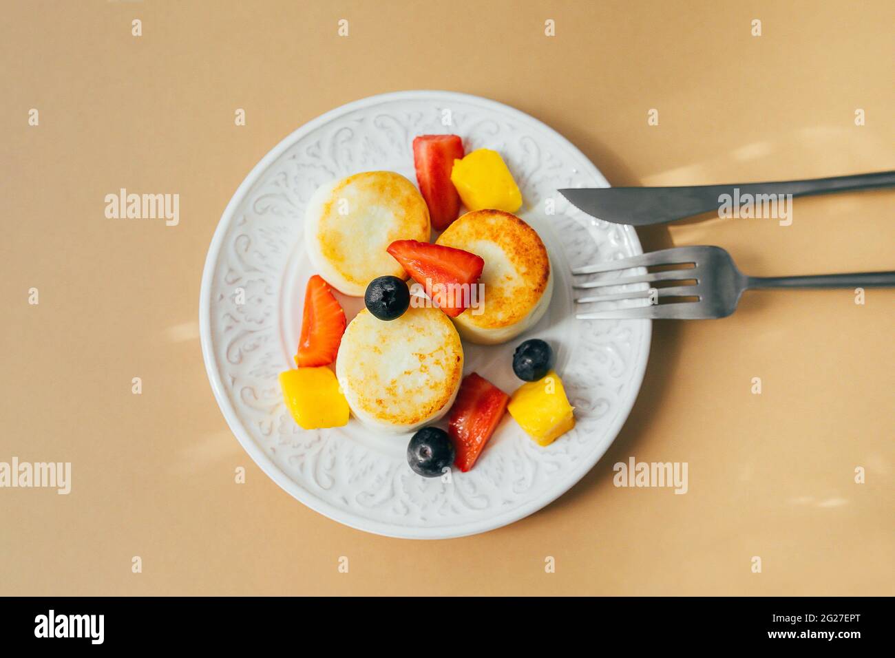 Breakfast food concept. Cottage cheese pancakes on plate. Syrniki with berry, top view. Stock Photo