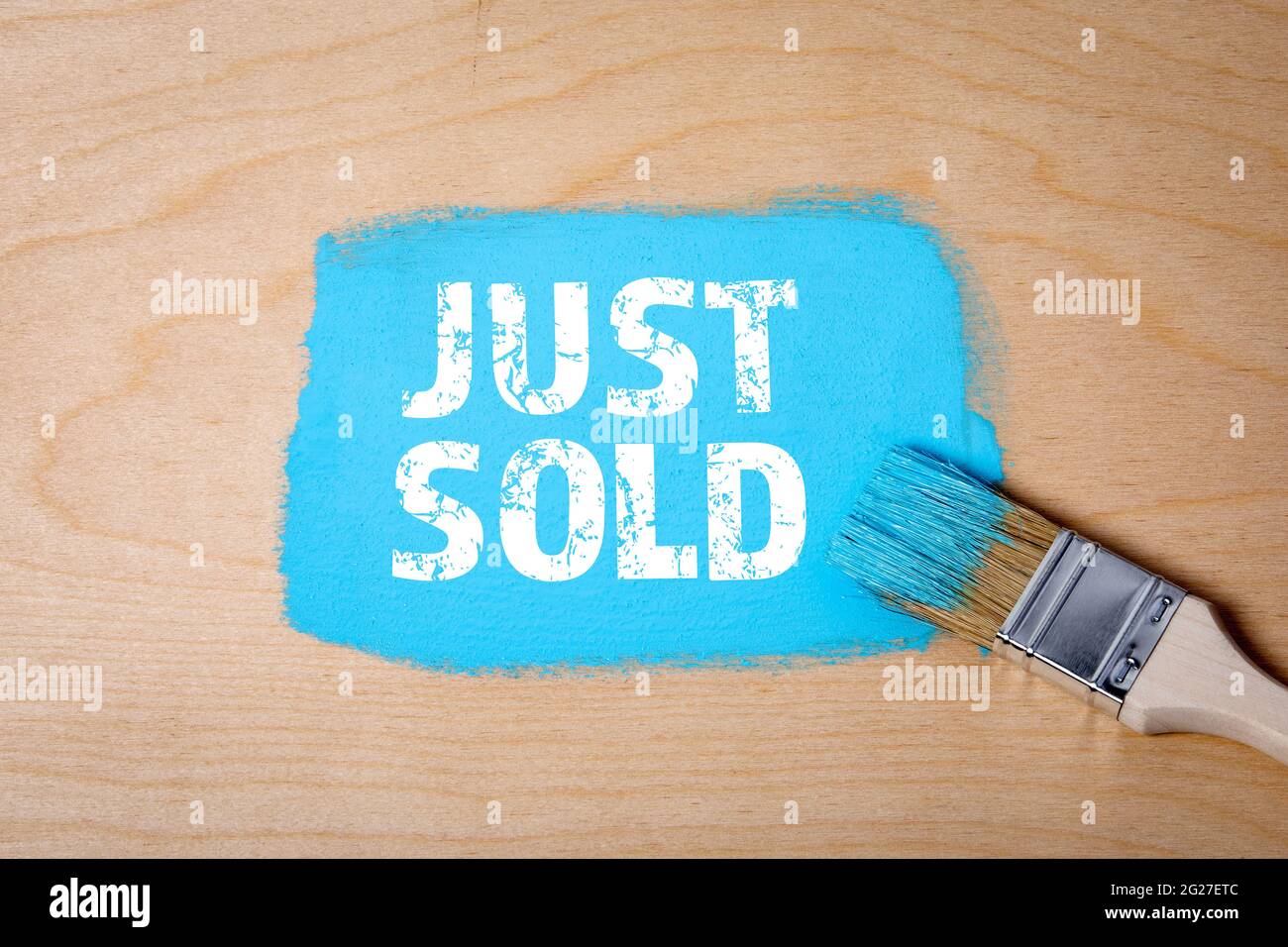 JUST SOLD. Paint brush with blue paint on a wooden surface. Stock Photo