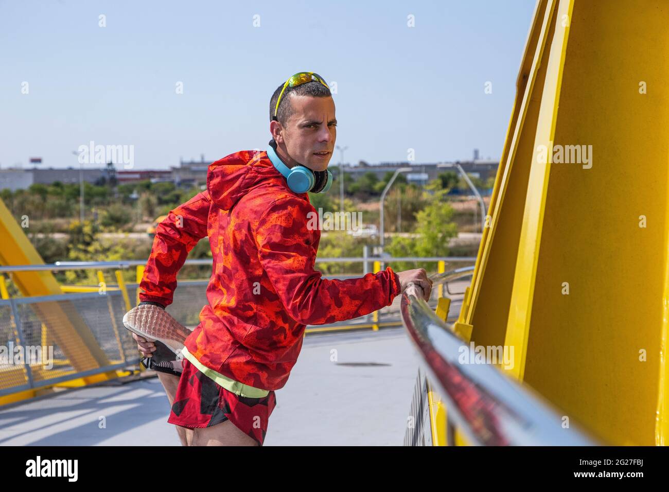 Runner warming up on a yellow bridge outdoors Stock Photo