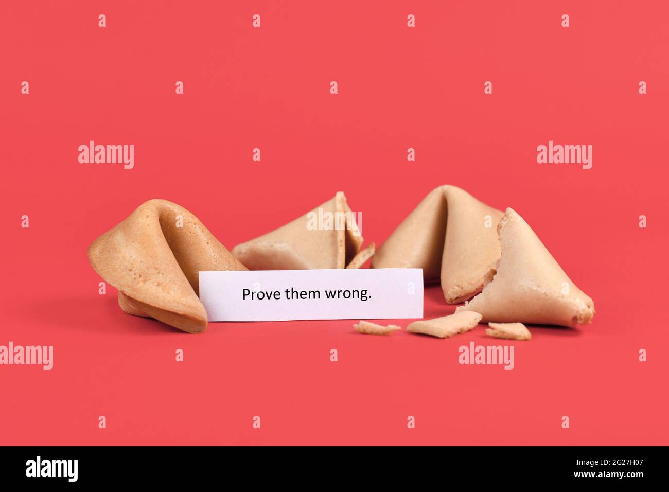 Fortune cookies with motivational text saying 'Prove them wrong' on red background Stock Photo