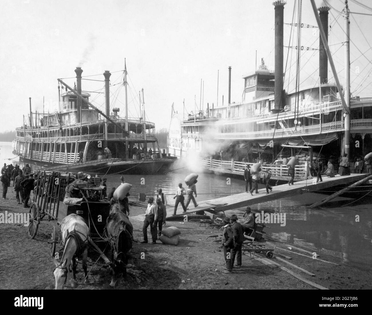 Two Mississippi River steamboats being loaded with cargo by dock workers in Memphis, Tennessee. Stock Photo