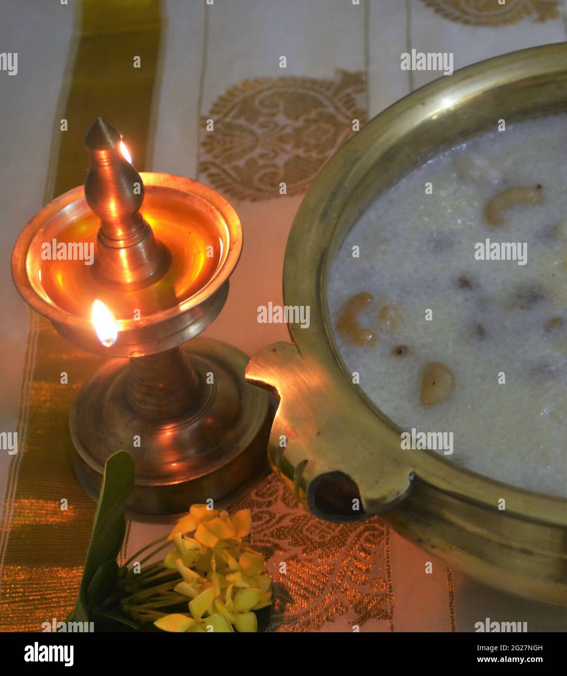 Lit,brass oil lamp/rice kheer/payasam in a brass urli-Onam festival/Kerala Stock Photo