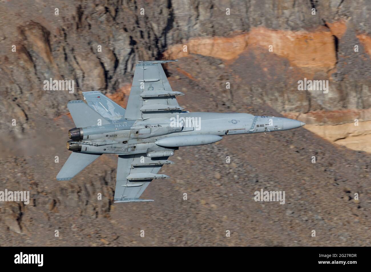 A U.S. Navy F/A-18C Hornet flies through Death Valley, California. Stock Photo
