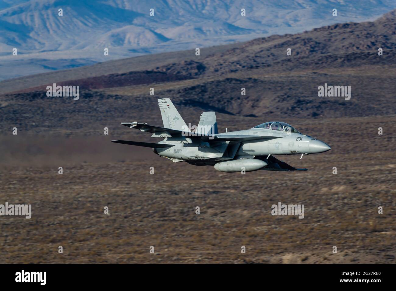 A U.S. Navy F/A-18F Super Hornet flies through Death Valley, California. Stock Photo