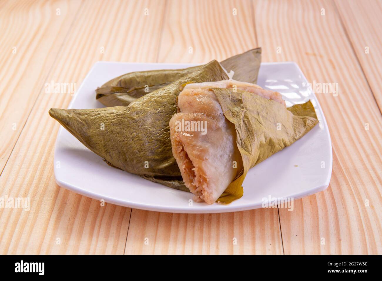 Ela Ada or Steamed sweet rice  dumblings,steamed rice cakes wrapped in banana leaf,Kerala traditional snacks item, arranged in a white ceramic plate Stock Photo