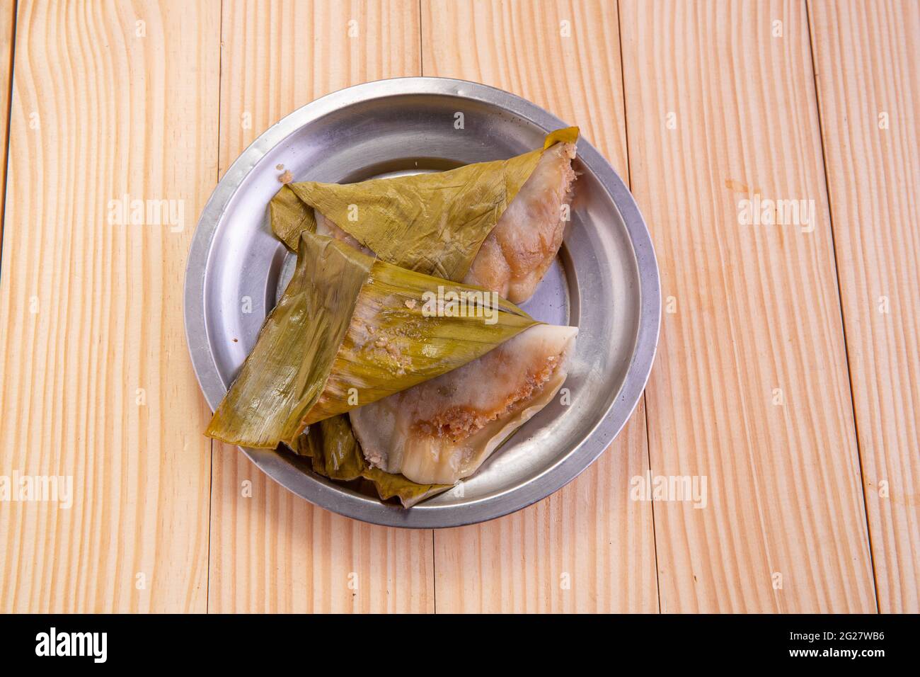 Ela Ada or Steamed sweet rice  dumblings,steamed rice cakes wrapped in banana leaf,Kerala traditional snacks item, arranged in a steel  plate . Stock Photo