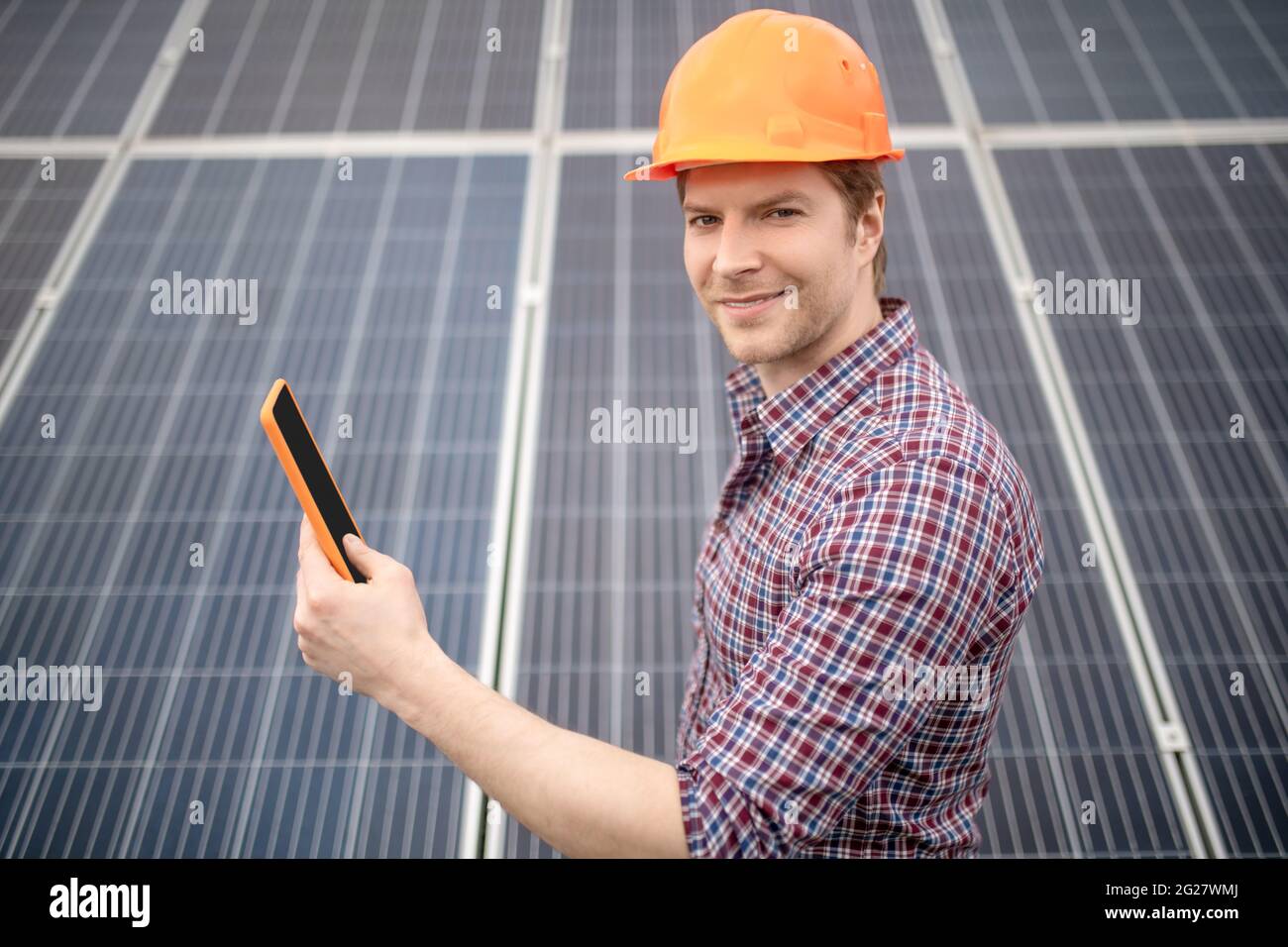 Smiling man in safety helmet while working Stock Photo