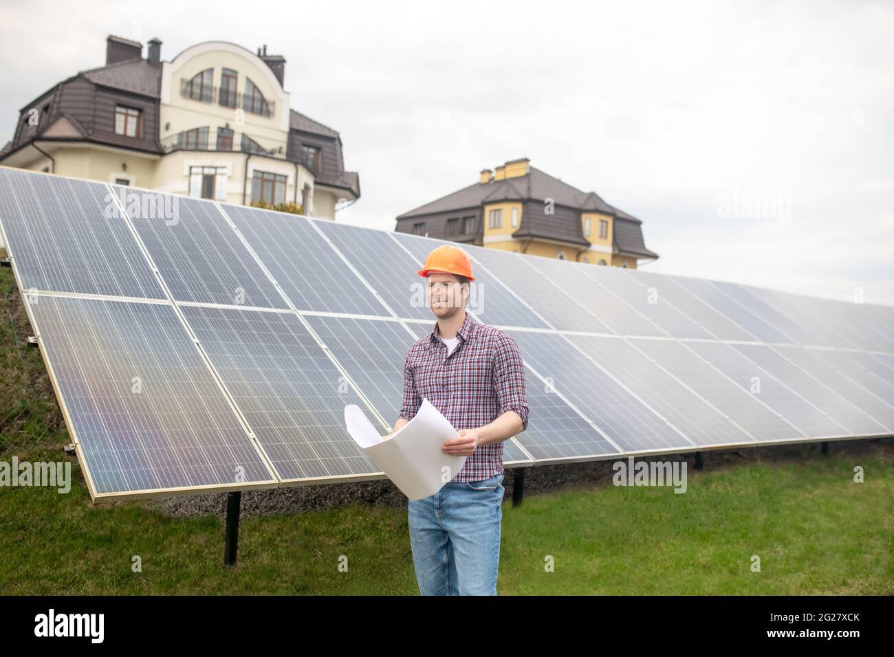 Smiling man with drawing on solar panel background Stock Photo