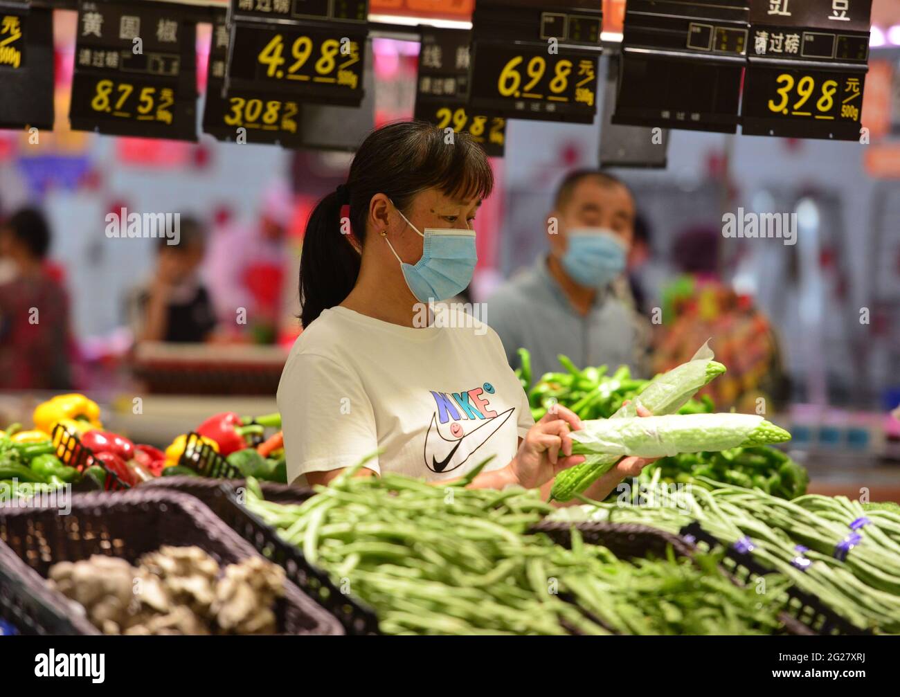 Fuyang, China. 09th June, 2021. A woman shops for fresh vegetables at RT Mart supermarket.China's consumer price index, a main gauge of inflation, grew by 1.3 percent year-on-year last month, up from 0.9 percent in April, the National Bureau of Statistics said on Wednesday. The CPI reading picked up as food prices rose amid a tight supply of freshwater fish and eggs while non-food prices increased with transportation costs elevated by rising international crude oil prices, the NBS said. Credit: SOPA Images Limited/Alamy Live News Stock Photo