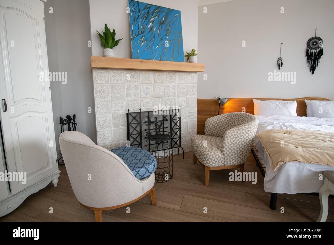 Cozy bedroom with fireplace and painting Stock Photo Alamy