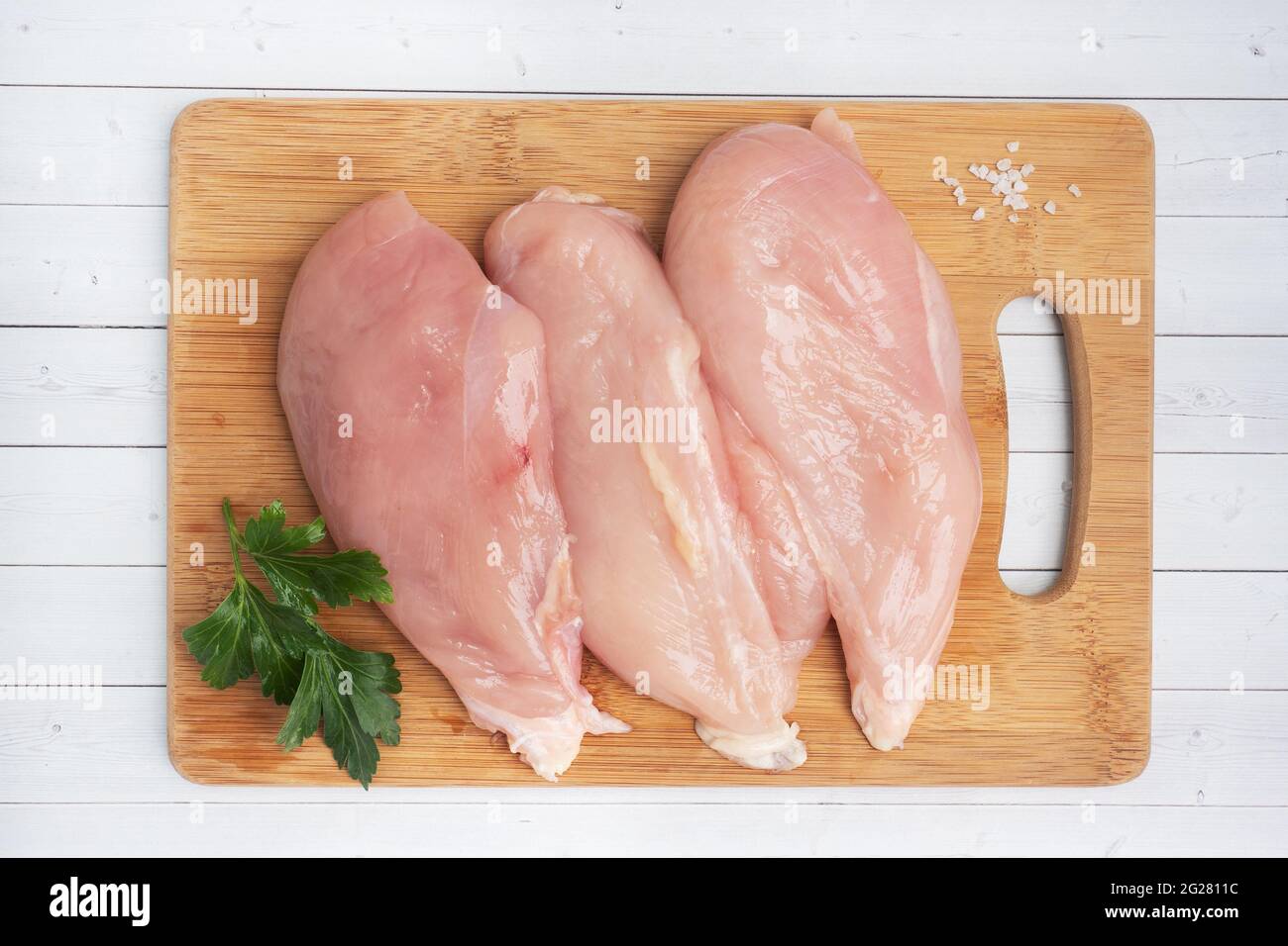 Raw chicken breast fillet, raw chicken meat on a cutting Board. White background Stock Photo