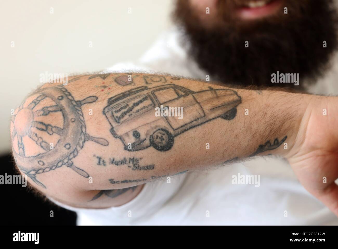Tattoos of an English rose, Mr Bean, Del Boy and R2-D2 pictured on a mans arm in Portsmouth, Hampshire, UK. Stock Photo