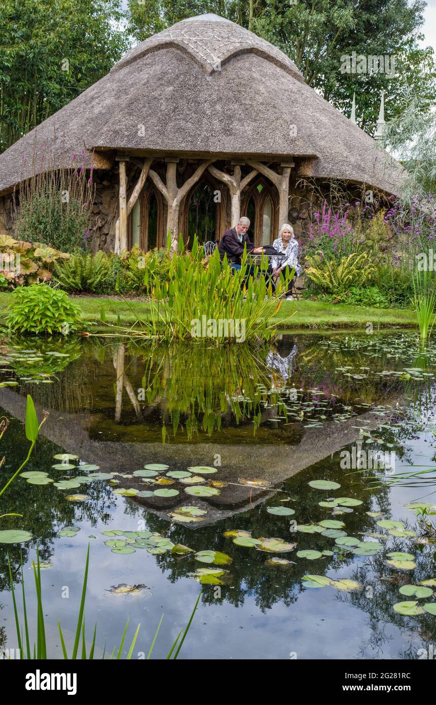 A thatched arbour overlooking an ancient fishpond in the gardens of The