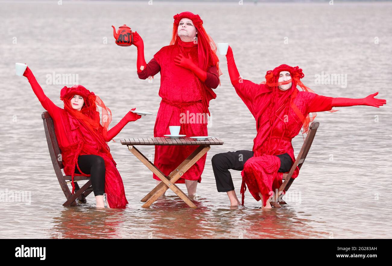 The Red Rebel Brigade hold a 'Tea in the Sea' protest in Belfast Lough at Seapark, Co. Down, ahead of the G7 summit to highlight rising sea levels. Stock Photo