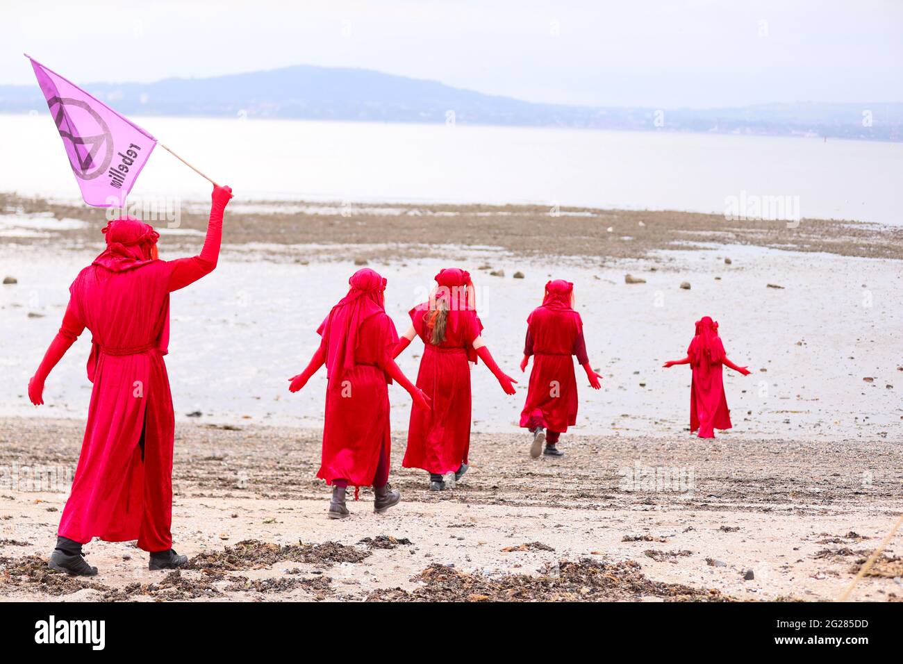 The Red Rebel Brigade hold a 'Tea in the Sea' protest in Belfast Lough at Seapark, Co. Down, ahead of the G7 summit to highlight rising sea levels. Stock Photo