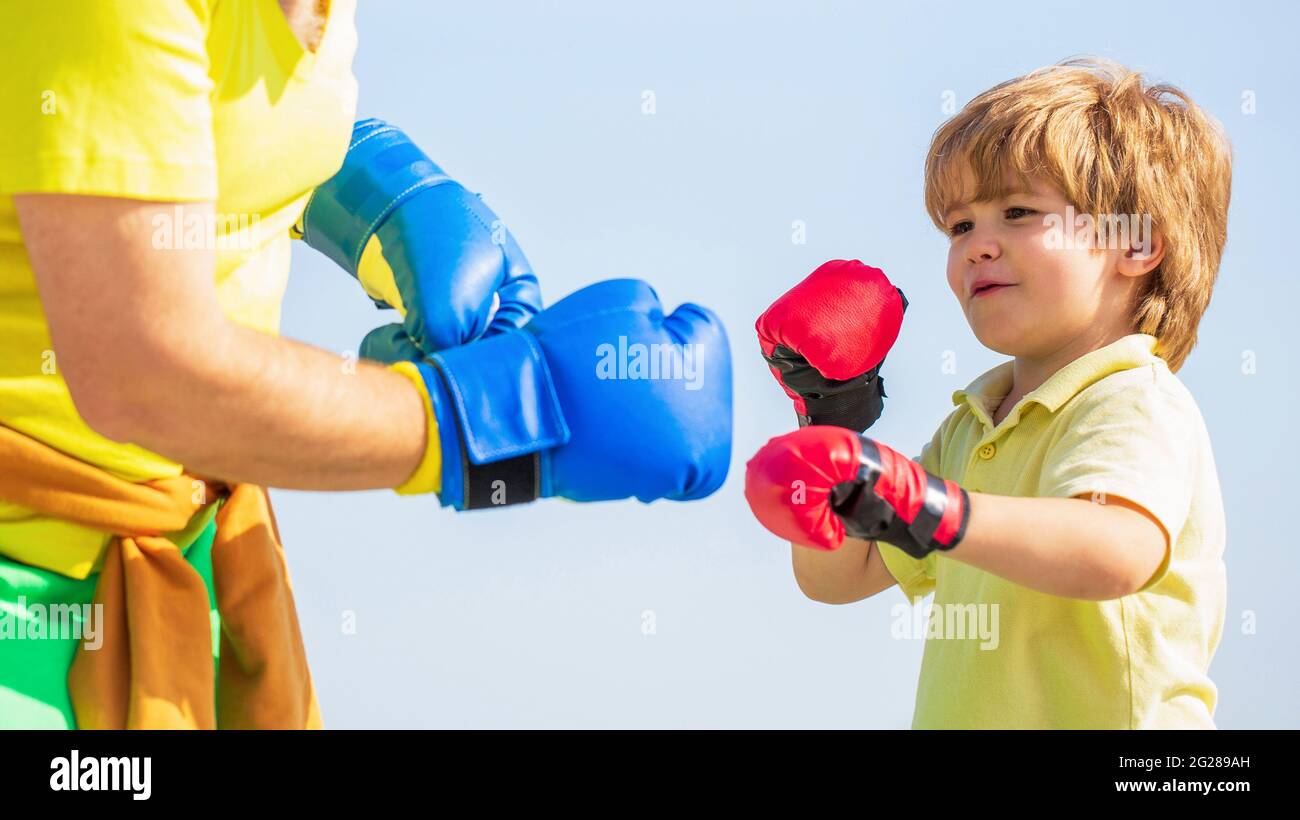 Father is training his son boxing. Little boy sportsman at boxing training with coach. Little