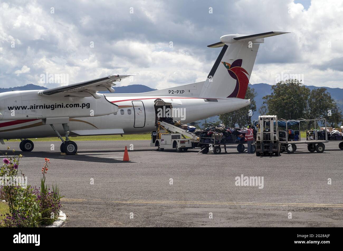 Papua New Guinea, Goroka - airport; The plane on the tarmac. Loading luggage on the plane. Lotnisko, samolot, bagaż; Flughafen Stock Photo