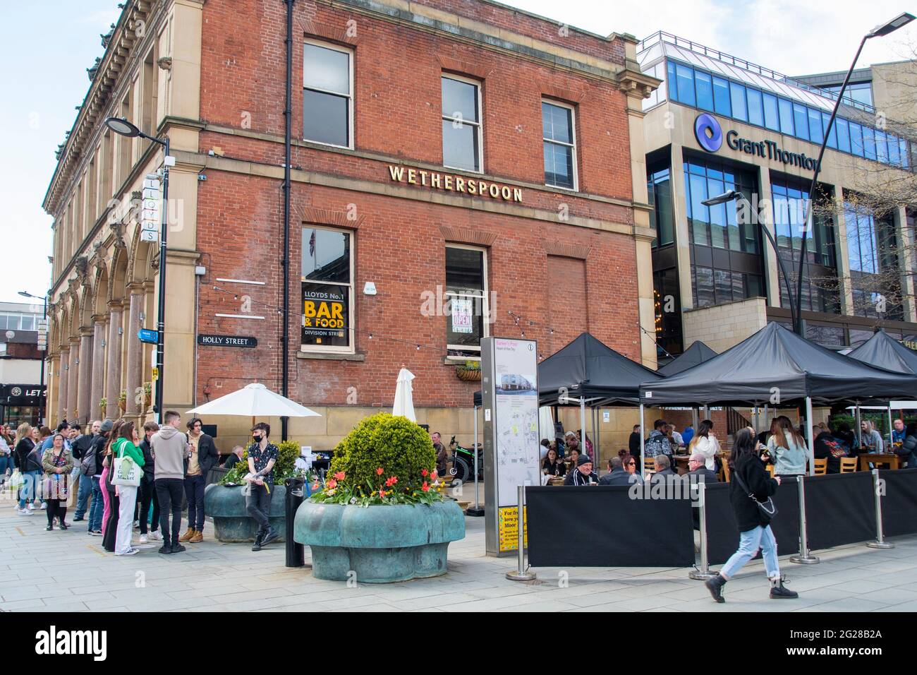 Sheffield UK: 17th April 2021: socially distanced queuing at Wetherspoons as pubs reopen after the pandemic. The New Normal on West Street Stock Photo