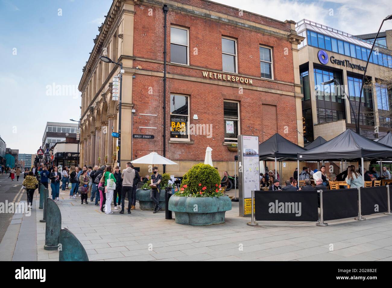 Sheffield UK: 17th April 2021: socially distanced queuing at Wetherspoons as pubs reopen after the pandemic. The New Normal on West Street Stock Photo