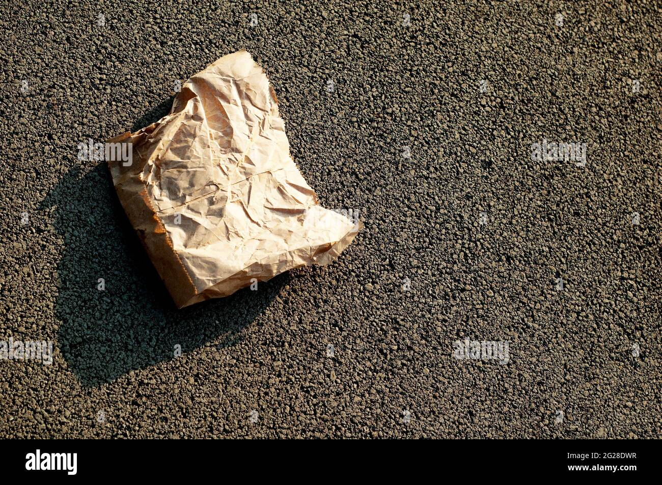 A thrown away paper bag lying on the road Stock Photo