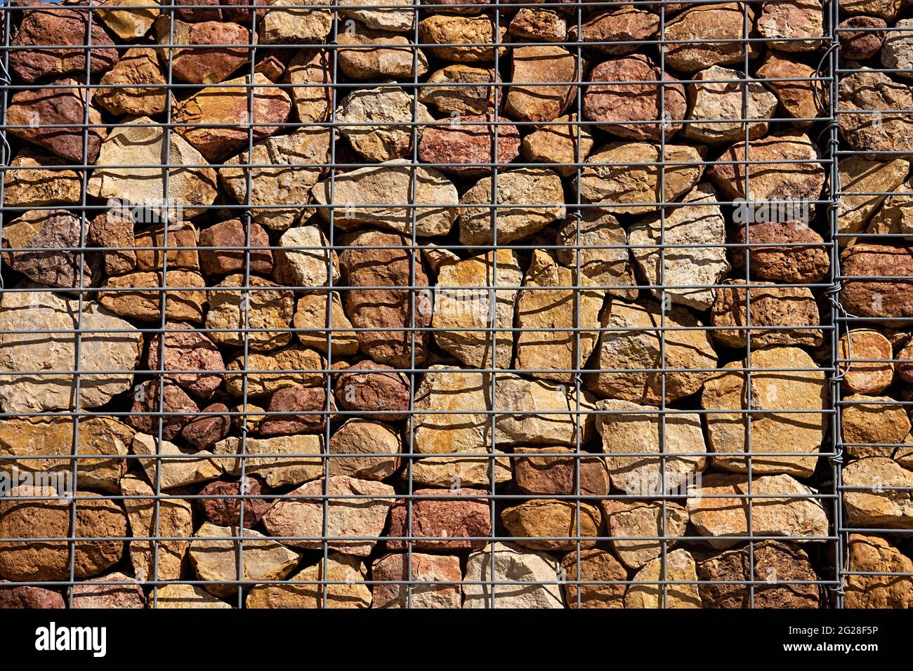 Gabion walls, a low cost economical construction method for building  retaining walls made by stacking rocks and stones in a steel cage. Stock Photo