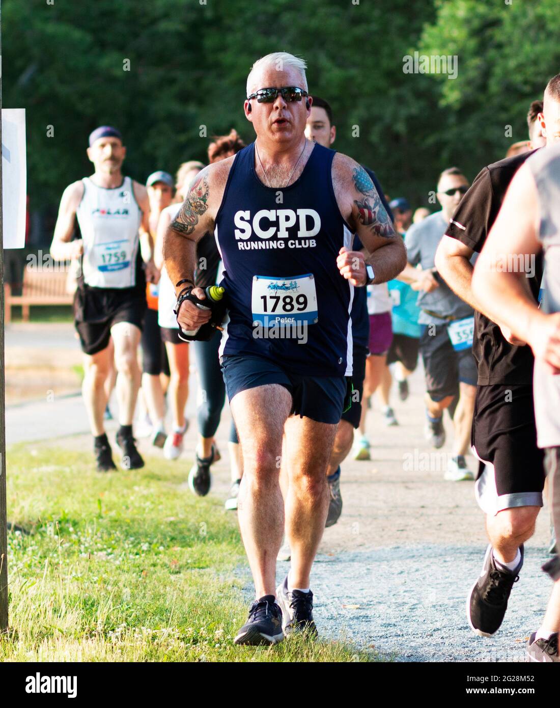 North Babylon, New York, USA – 8 July 2019: A member of the Suffolk County Police Department running club running a 5K race at Belmont Lake State Park Stock Photo