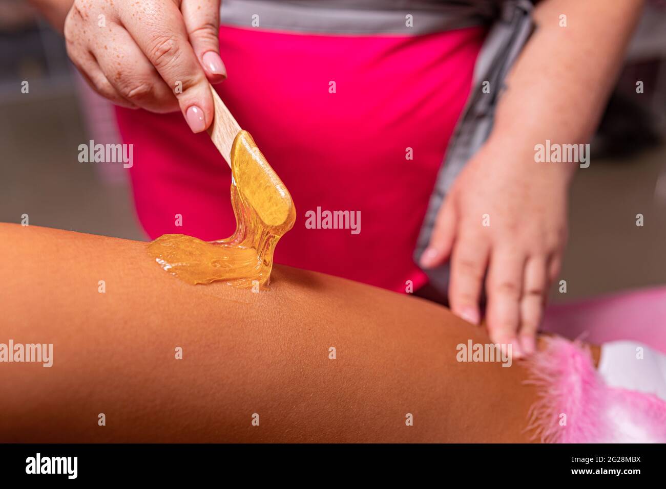 waxing procedure in a massage parlor wax on the body Stock Photo