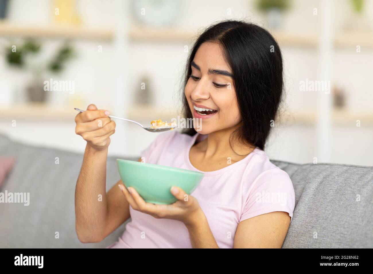 Balanced nutrition concept. Lovely Indian lady eating delicious cereal