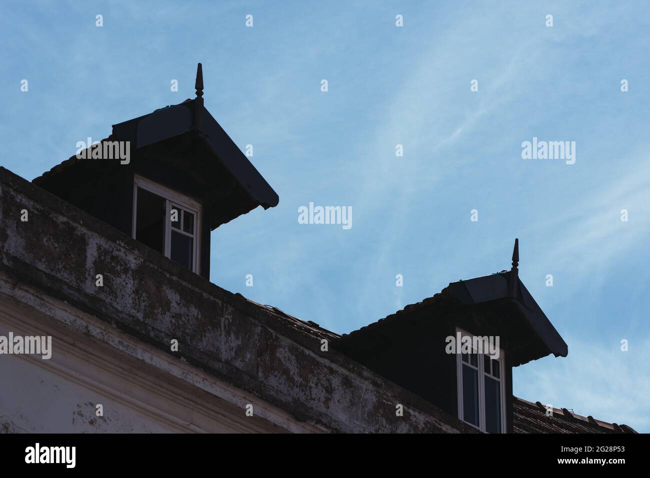 Low angle shot of two false dormer windows on a shingles covered roof Stock Photo