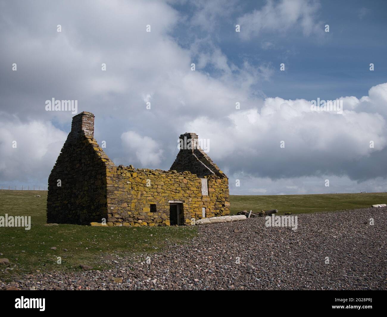 An abandoned, derelict croft or farm house on a pebble beach at Stenness, Northmavine in  Shetland, Scotland, UK Stock Photo