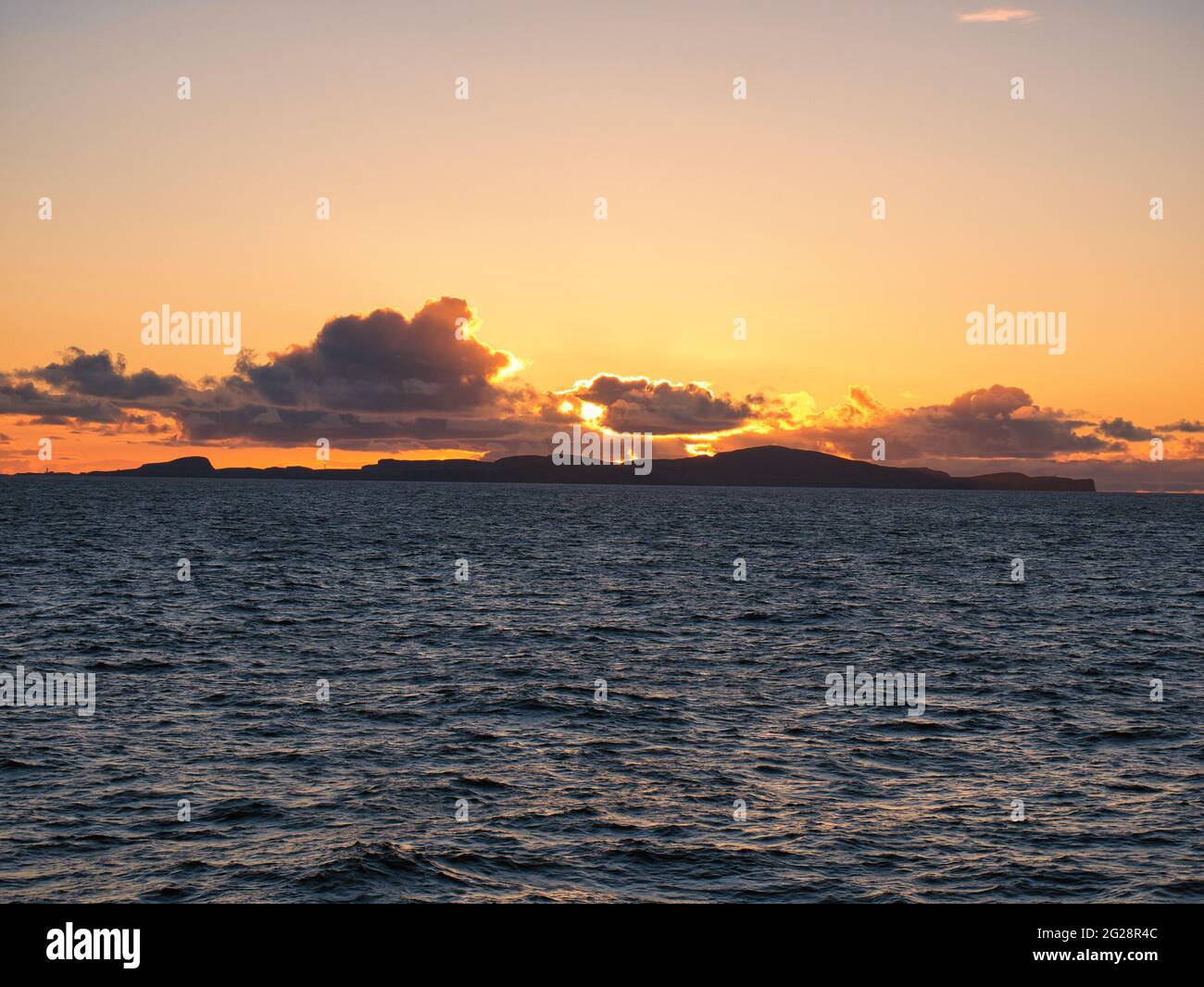 Sunset over the island of Fair Isle, part of the Shetland archipelago in the north of the UK. Taken on a sunny evening from the ferry travelling from Stock Photo