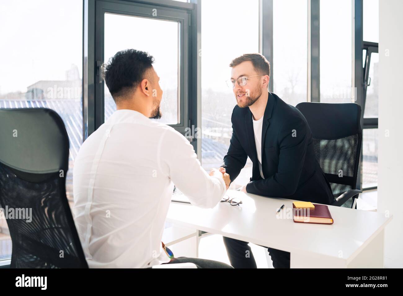 Two businessmen in the office greet each other Stock Photo - Alamy