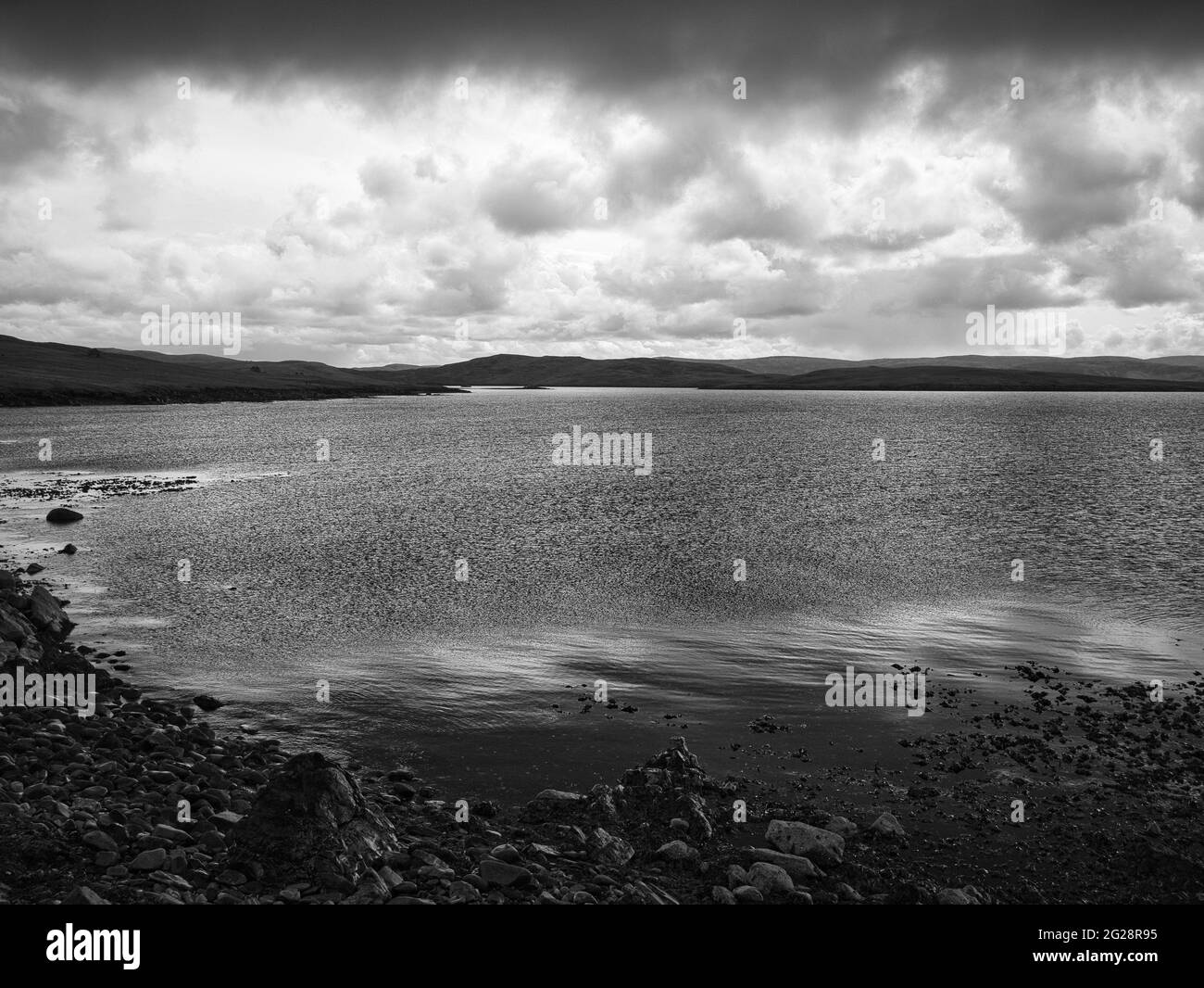 A grainy, moody black and white view of shore, sea and clouds from Outrabister on Lunna Ness, Shetland, UK Stock Photo