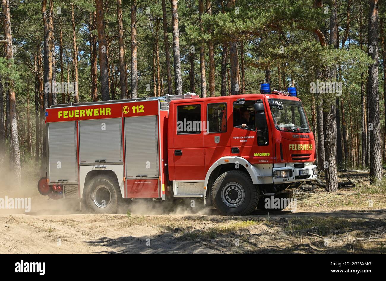 09 June 2021, Brandenburg, Wünsdorf: A fire engine of the fire department is on its way to a fire in a pine forest near Wünsdorf. With the rising temperatures, the danger of forest fires has increased in Brandenburg. Currently, forest fire danger level 4 is in effect throughout the state of Brandenburg. Two forest fire centers in Wünsdorf (Teltow-Fläming) and Eberswalde (Barnim) monitor the events in the state. From stage 3 onwards, they are manned. According to the Ministry of the Environment, last year there were 299 forest fires in Brandenburg on 118.5 hectares of land. Photo: Patrick Pleul Stock Photo