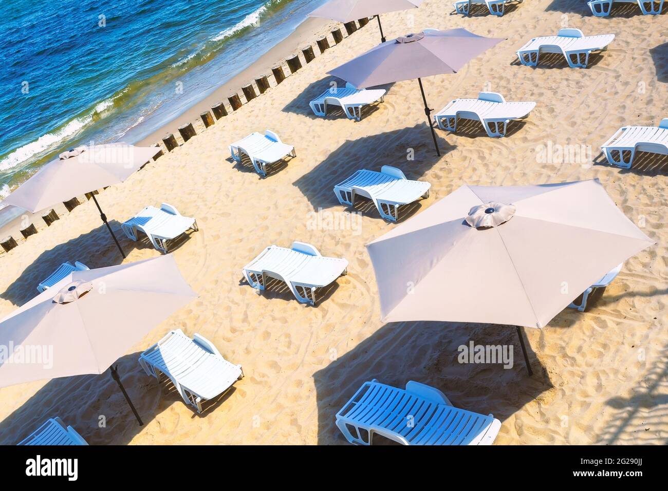 Empty deck chairs and sun umbrellas on a sandy beach. Stock Photo