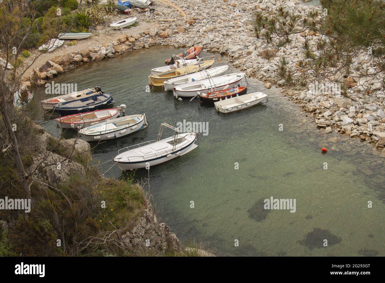 Empty boats and the island of Giglio in Grosseto, Italy Stock Photo