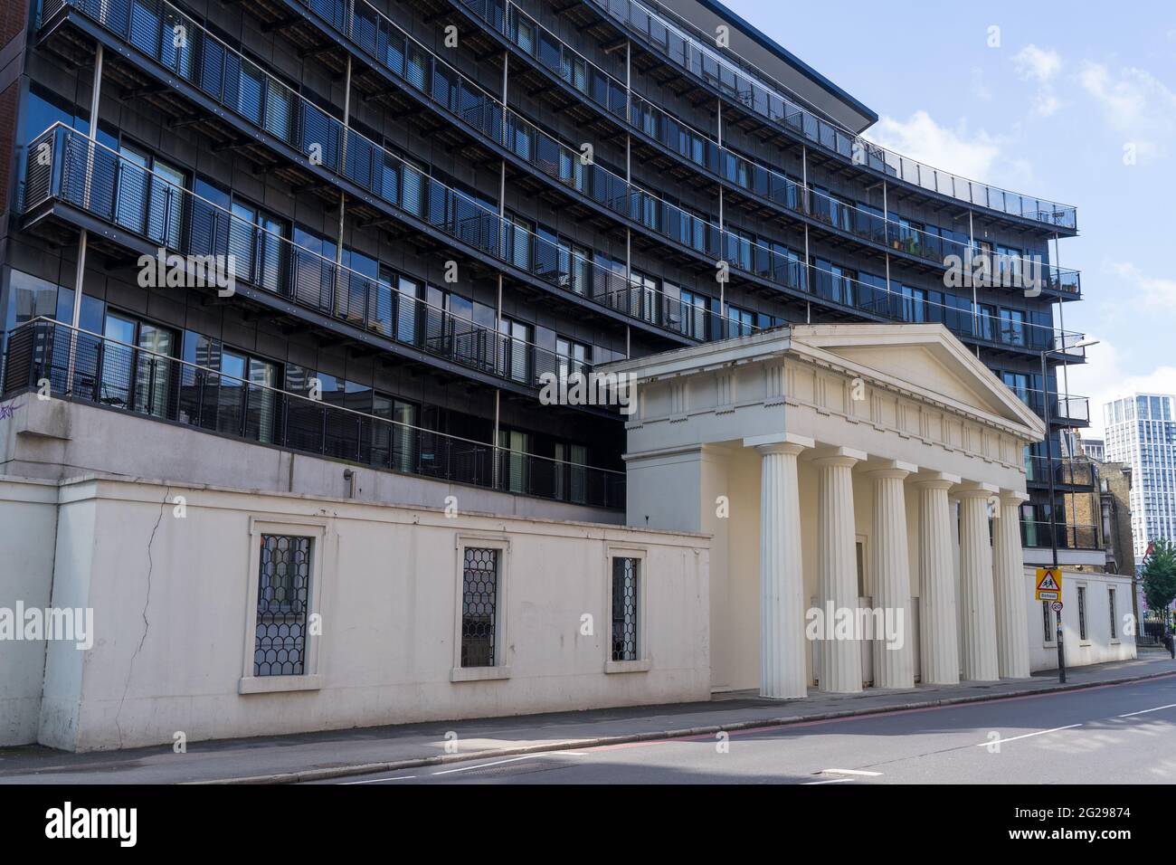 An old white column facade of a building in front of new luxury flats on Stamford Street. London - 5th June 2021 Stock Photo