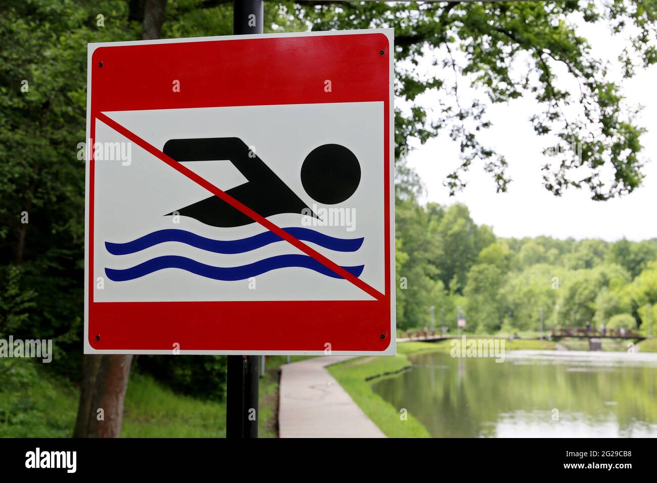 No swimming sign on background of summer lake. Beach holiday in city park Stock Photo