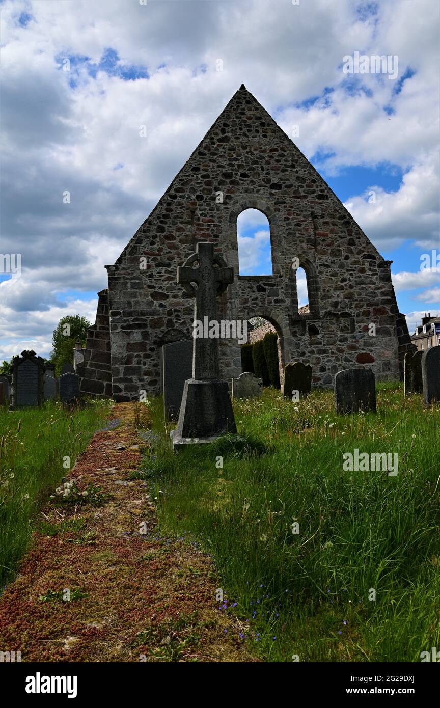 A view of the ruins of an old church building and graveyard in