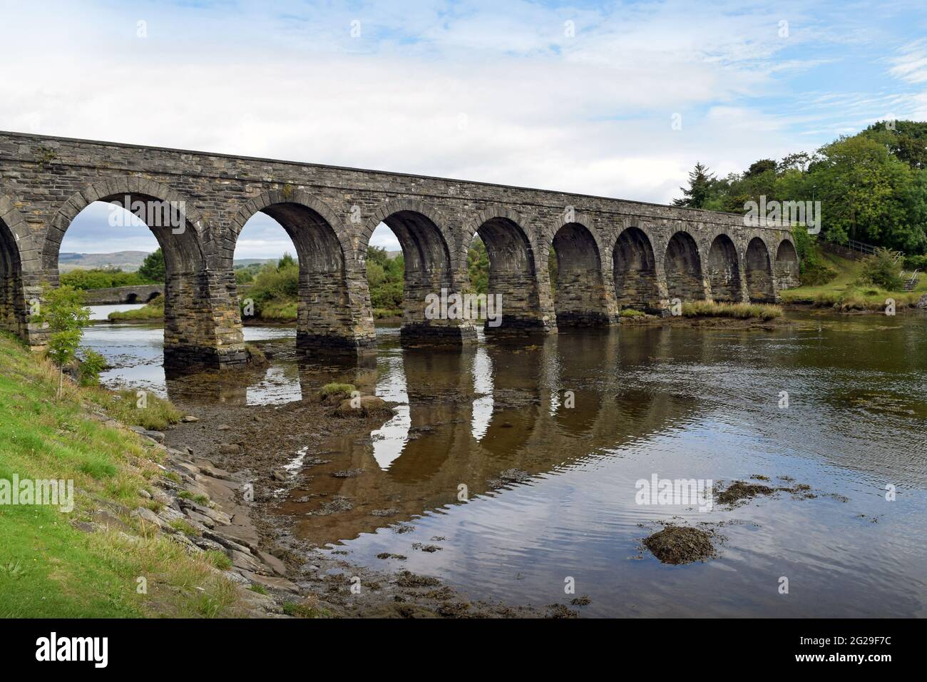 A 12 arch stone bridge / viaduct over a tidal inlet in Ballydehob, West Cork, Ireland. Stock Photo