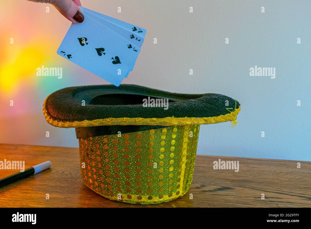 Magic show magicians trick concept background. Children's magic box with sequined top hats, magic wand, playing cards, cup and ball trick, secret draw Stock Photo