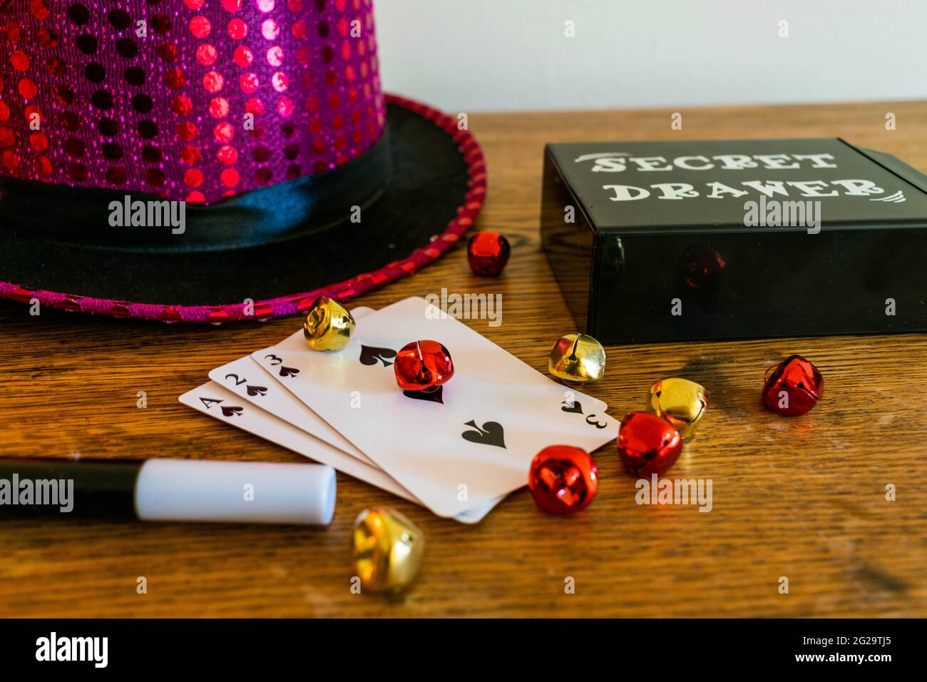 Magic show magicians trick concept background. Children's magic box with sequined top hats, magic wand, playing cards, cup and ball trick, secret draw Stock Photo