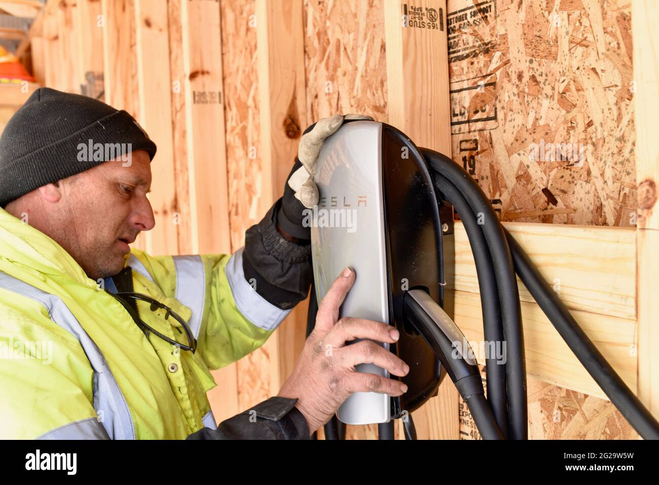 Electrician installing Tesla Charger mounted inside garage at private residence used for recharging Tesla electric vehicles, Browntown WI, USA Stock Photo