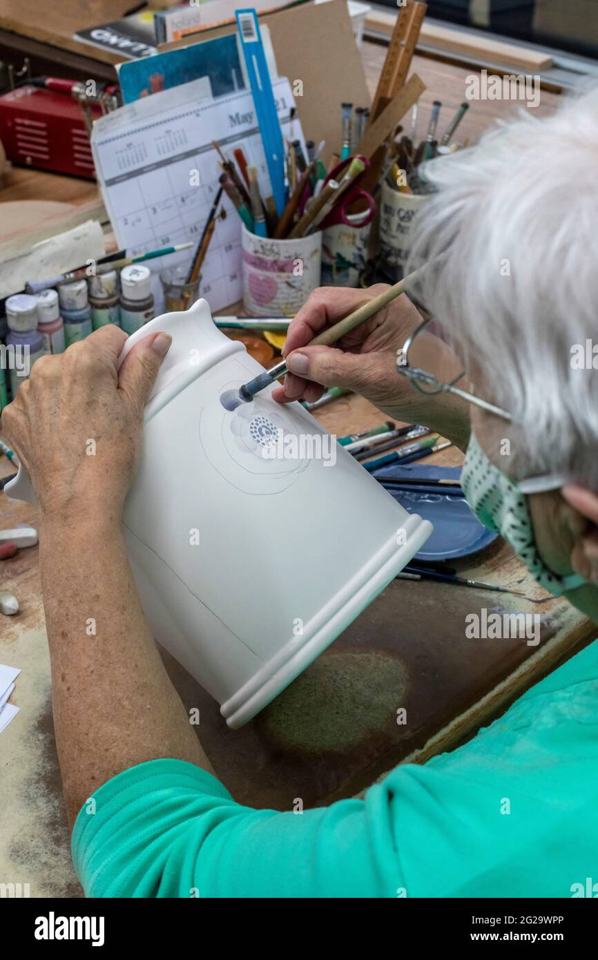 Holland, Michigan - An artist paints Delftware at the De Klomp Wooden Shoe and Delft Factory, part of the Veldheer Tulip Farm. The city's Dutch herita Stock Photo
