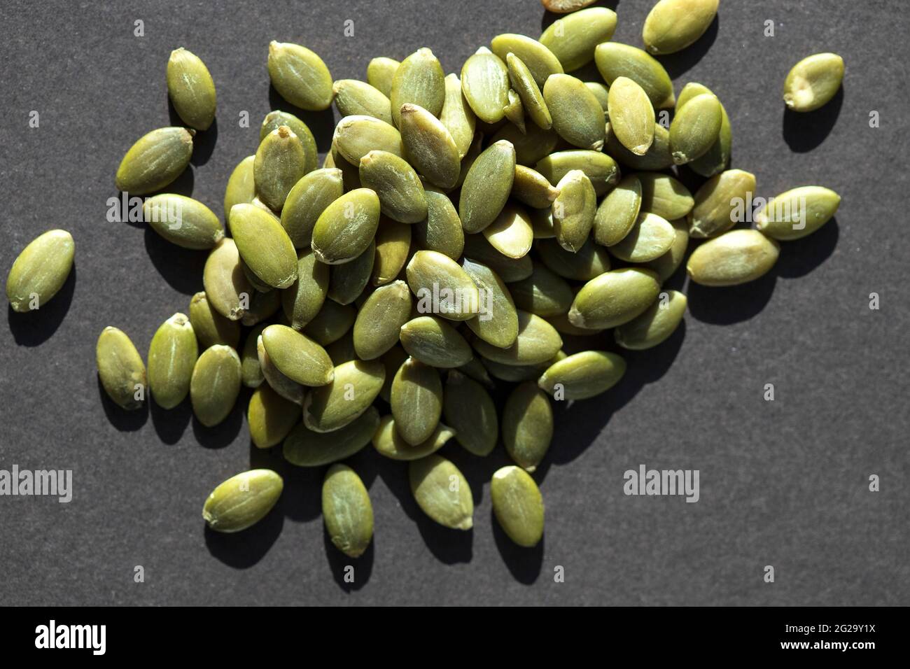 Organic pumpkin seeds in close up view on dark background. Stock Photo
